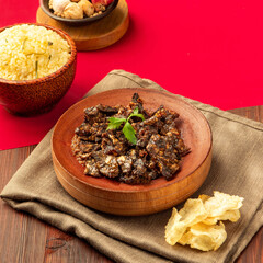 Fried beef lung, A savory dish features tender seasoned meat alongside fluffy rice and crispy snacks, arranged beautifully on a rustic table setting