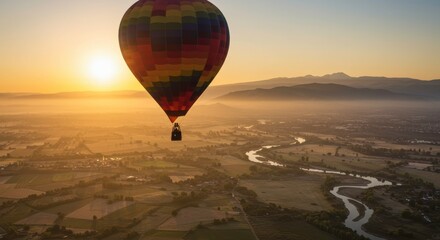 Obraz premium Sunrise Hot Air Balloon Ride: A vibrant hot air balloon ascends gracefully against the breathtaking backdrop of a sunrise over a vast, scenic landscape.