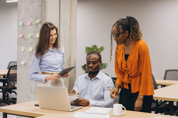 Diverse team working together analyzing data and sharing ideas, promoting teamwork and collaboration in modern workplace