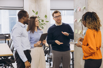 Obraz premium Business colleagues discussing new ideas using sticky notes during a productive meeting in a contemporary office space