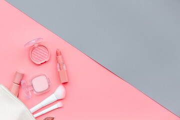 Makeup accessories in cosmetic bag - brushes and brown pink shade cosmetic products, top view