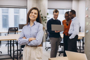 Confident businesswoman smiling, professional team working together in contemporary workplace, embodying corporate collaboration