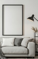 A modern living room with a light grey sofa, a black floor lamp, and a shelf on the right side of a picture frame. The poster frame on the wall is blank. 