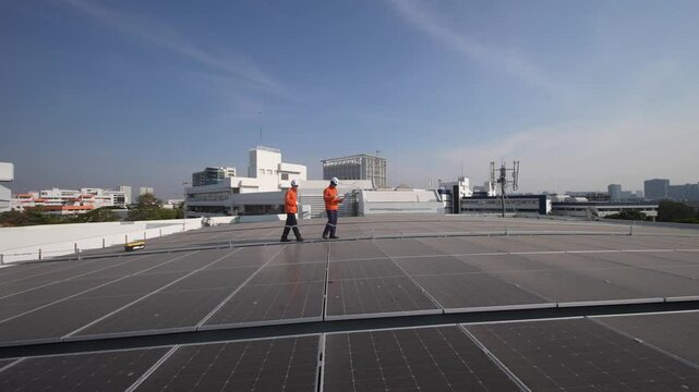 A technician inspects and repairs solar panels on a rooftop installation. The worker wears protective gear and focuses on ensuring the system is functioning well. The sky is clear and bright.