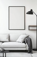 A modern living room with a light grey sofa, a black floor lamp, and a shelf on the right side of a picture frame. The poster frame on the wall is blank. 
