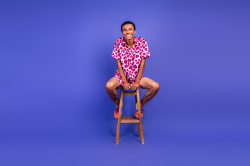 Fototapeta premium Fashionable young man in a leopard print outfit posing stylishly against a vivid purple background