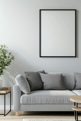 Fototapeta premium A simple living room with an empty black frame on the wall above a grey sofa and shelf, a minimalist interior design of a modern home entryway, front view. Stock photo with 2/3 space for text.