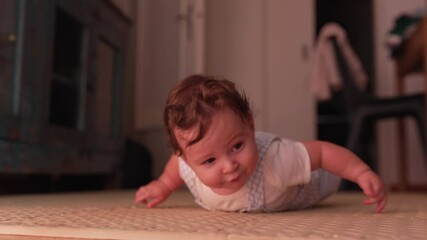 Baby rolling over on floor, testing balance and motor skills, engaged in developmental playtime, practicing movement milestones in warm and inviting home environment