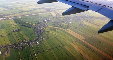 View from the plane to the spring fields. Aerial view on the agriculture fields in the landscape of the Netherlands