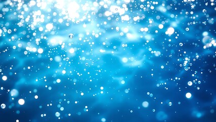 Blurry blue water surface with shimmering bubbles and gentle splashes, illuminated by sunlight, creating a tranquil natural background with ample space for text or design elements.