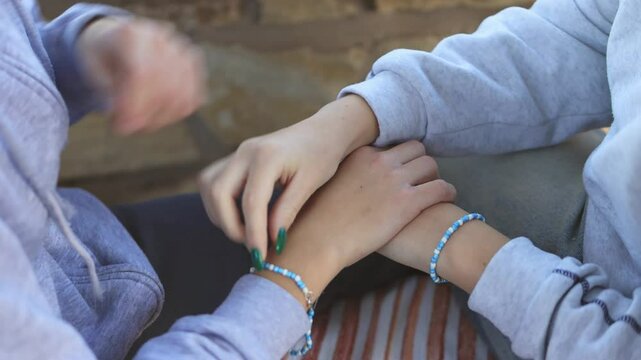 Matching friendship bracelets adorning wrists, young companions sharing  moment, symbolizing close emotional connection and unbreakable trust between friends.Happy friendship day
