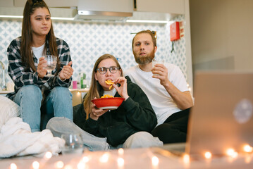 A Group of Friends Having a Fun Movie Night at Home, Enjoying Delicious Snacks Together