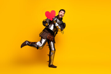 Fototapeta premium Happy knight in shining armor holding a heart on a bright yellow background