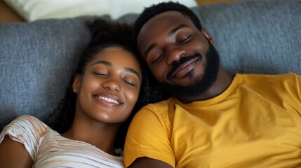 Obraz premium Relaxing young couple with closed eyes enjoying quality time together on a cozy gray sofa at home in warm colors and soft lighting
