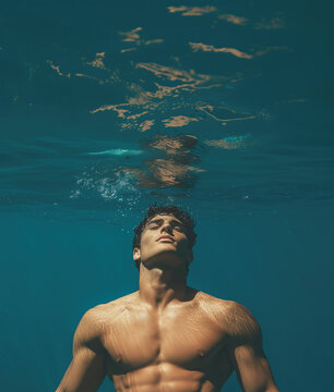 Fashion campaign concept. Portrait of handsome male nodel under blue water. Text space. Poster style. Underwater shot