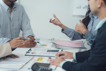 Business Discussion: A group of diverse professionals collaborate around a conference table, engaged in a lively and animated discussion, focused on data and documents.