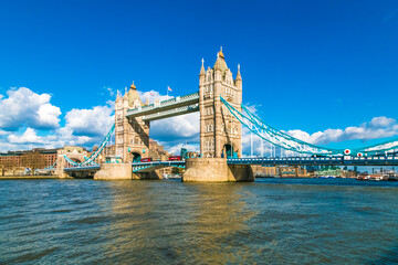 Lovely panoramic view of the iconic Tower Bridge over the River Thames on a sunny day with a blue sky in London. The combined bascule and suspension bridge is London's defining landmark.