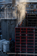 building under construction and workers on a cold day
