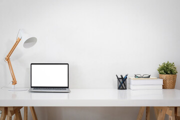 A white work desk stands near a white wall. front view