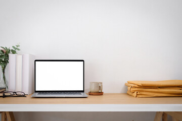 Work desk with documents and laptop, blank screen front view