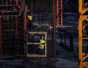 building under construction and workers on a cold day