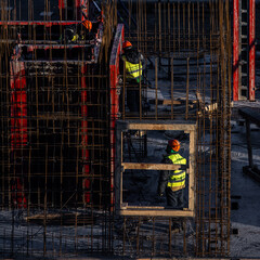 building under construction and workers on a cold day