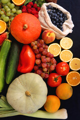 Various healthy fruits, vegetables and cereals on dark background. Top view.
