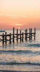 Fototapeta premium A broken wooden pier going out to sea at sunset