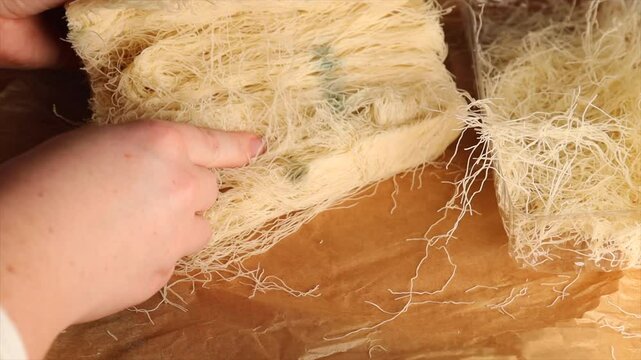 green and orange mold grows on delicate kataifi dough strands. visible fungus indicates raw pastry spoilage. concept of food hazard and contamination alert.