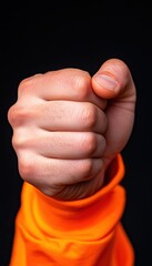 A clenched fist symbolizes strength, determination, and resilience against challenges in life.