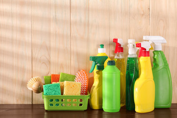 Different cleaning products and supplies on wooden table, space for text