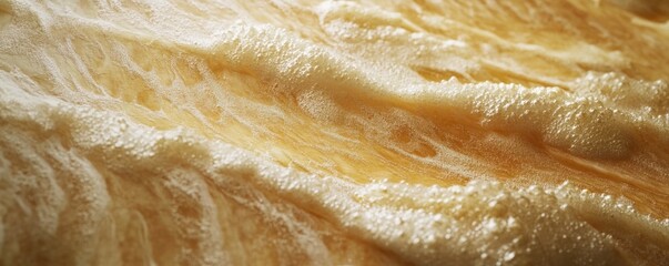 Obraz premium Golden liquid flowing, foamy texture, close-up, background blurred, food/drink use