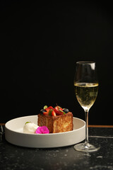 A plate of French toast topped with fresh berries and a glass of champagne. A delicious breakfast or brunch dish