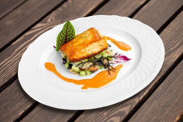 Fried tasty fish steak with cooked vegetables