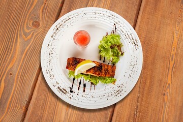 Fried tasty fish steak with cooked vegetables