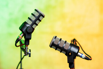 Microphones set up for a podcast interview recording in a vibrant studio setting with colorful backdrop