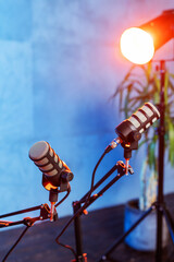 Two microphones set against a blue background for podcasting and broadcasting sessions in a studio environment