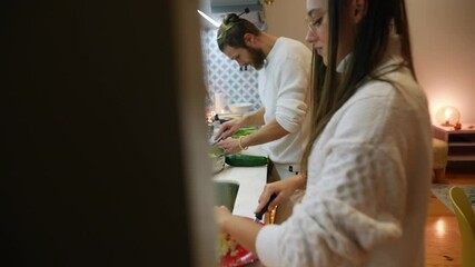 A couple is joyfully cooking together in a cozy kitchen that creates a warm atmosphere