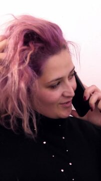 Vertical: Smiling pinkhead woman on the cell phone at home