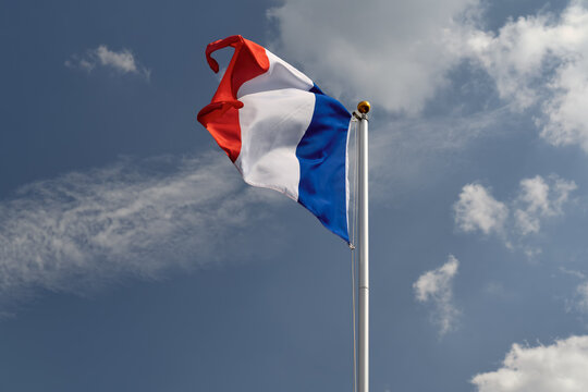 France flag waving on a flagpole, strong wind