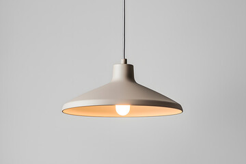 A modern grey pendant light hanging isolated on grey background