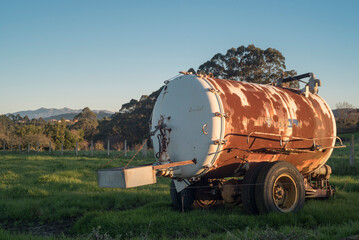Depósito de agua oxidado en parcela de pastos