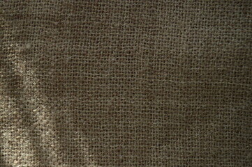 Close-up of rustic burlap texture, showcasing its coarse woven fibers and natural brown color, perfect for a rustic background.