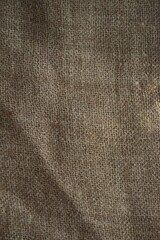 Close-up view of burlap fabric, showcasing its coarse, textured weave and warm brown tones.