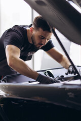 Car mechanic at car service checking up the car