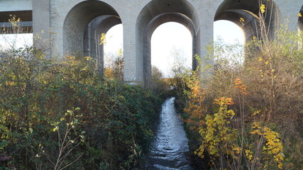 Railway bridge in the middle of the park in the city in autumn