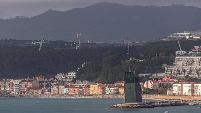 Aerial timelapse of Torre VTS de Lisboa, Lisbon's Vessel Traffic System tower for maritime coordination and safety overlooking the Tagus River. Colorful houses line the waterfront at evening. Portugal