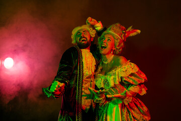 Fototapeta premium Elegant couple in illusion costume under dramatic lighting at themed carnival