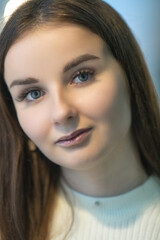 Portrait of a young beautiful dark-haired girl in a cafe.