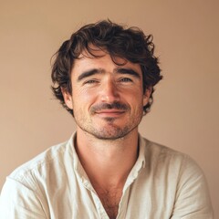 Obraz premium Man with curly hair smiles warmly in a soft-toned setting during daytime indoors. Generative AI